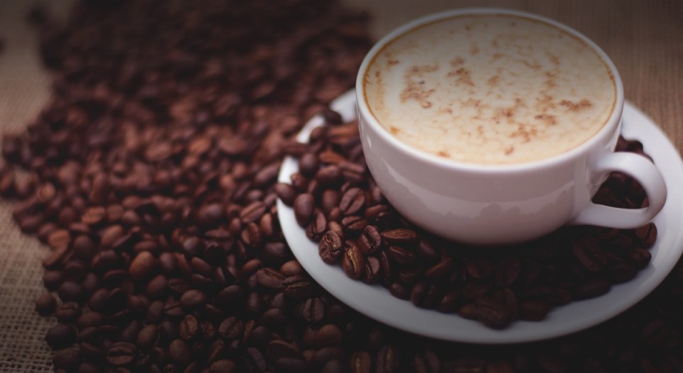 a cup of a coffee with lots of coffee granules beside it