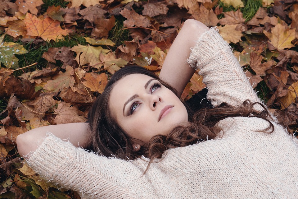 girl lying on dried leaves